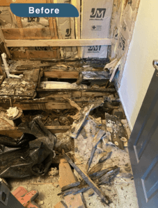 An image labeled "Before." This is a bathroom that has been completely demolished down to the rafters beneath the floor. The walls have no drywall and the plumbing and underflowing are all visible.