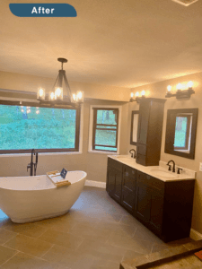 An image labeled "After." A beautiful bathroom with a deep soaking tub, two sink counter with dark wood finish, and beige tile floor. Mountain scenery is visible through the windows.