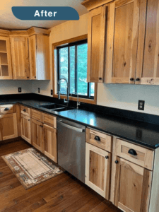 An after picture of a kitchen remodel in Evergreen, showing sink, wood cabinets and black countertops.