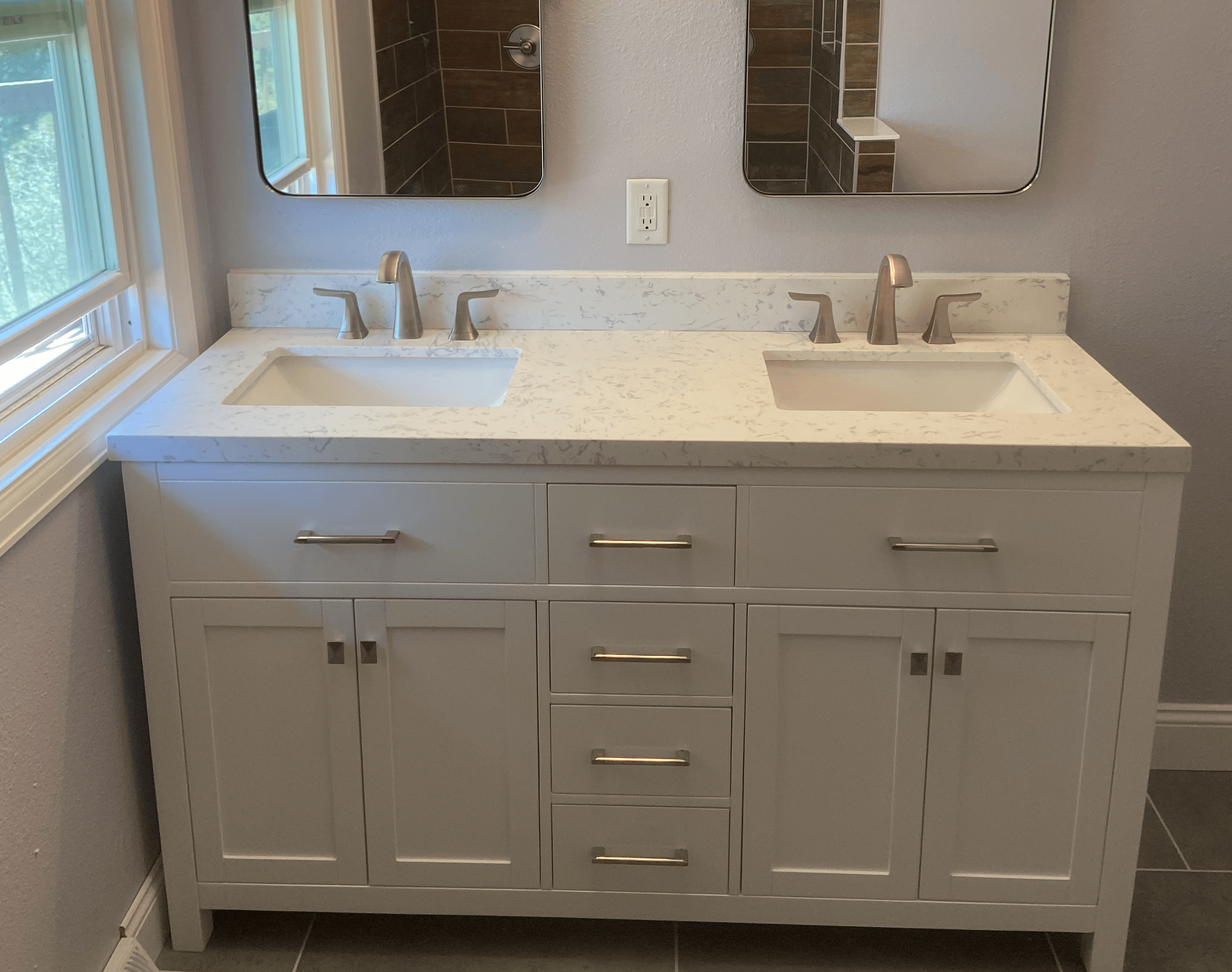 A vanity with two sinks and two mirrors.